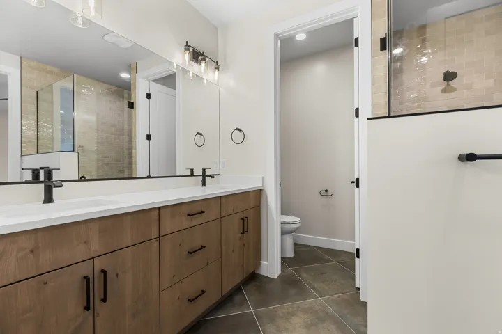 Bathroom featuring a dual-sink vanity with wood-finish cabinetry and white countertops