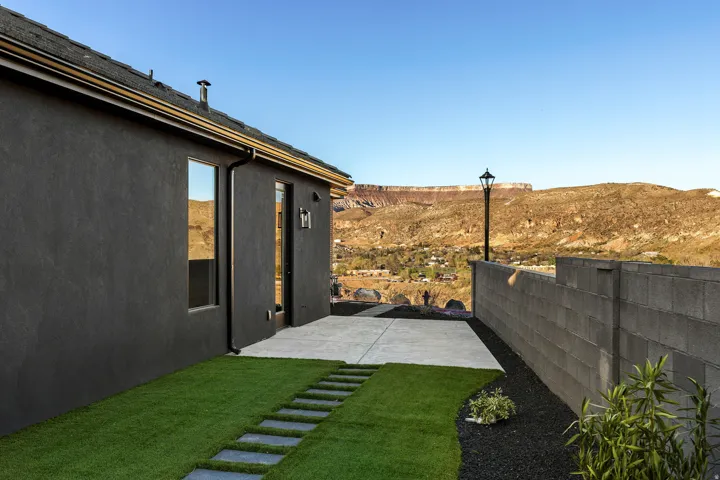 Modern exterior featuring dark stucco siding and a concrete patio