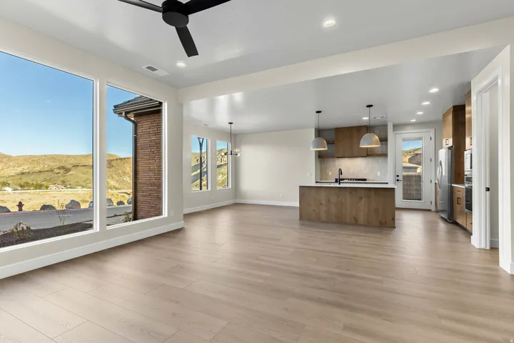Open-concept living area featuring wood-finish flooring, recessed lighting, and a modern ceiling fan