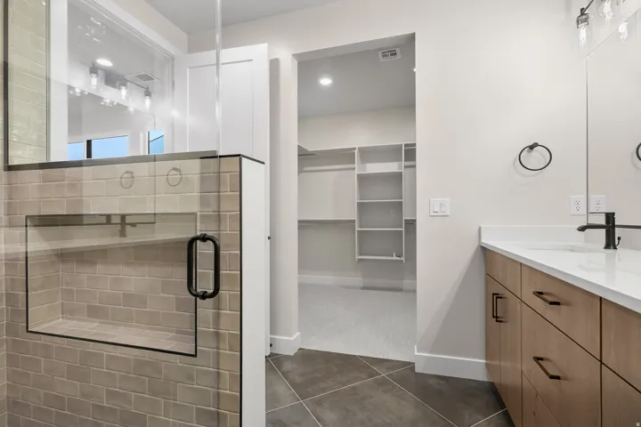 Modern bathroom featuring a glass-enclosed shower with subway tile, a built-in shower niche, and matte black hardware