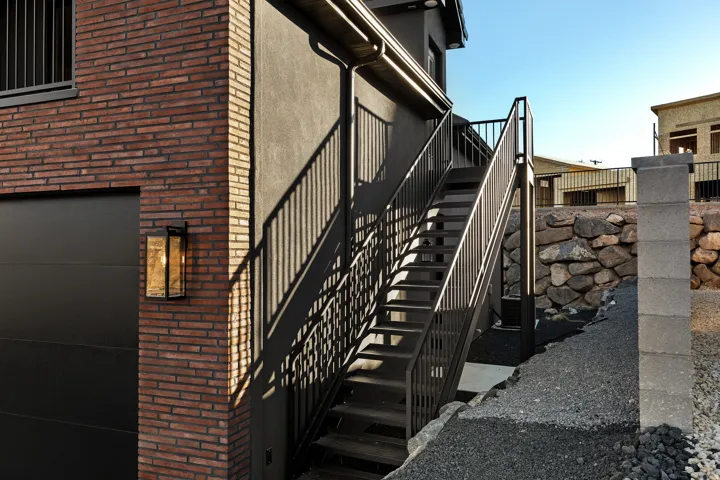 Contemporary exterior featuring dark brickwork and stucco siding