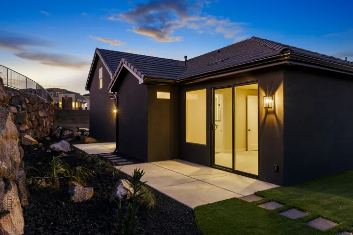 Exterior featuring a dark stucco finish and a dark tiled roof