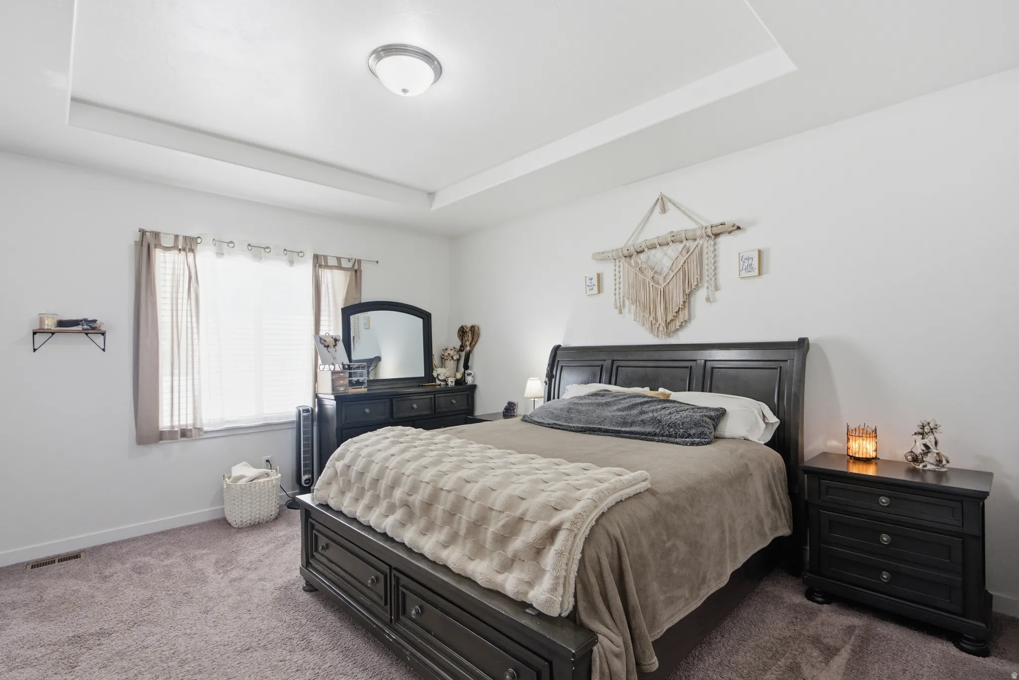 Spacious room featuring a tray ceiling with recessed lighting, carpet flooring, and a large window