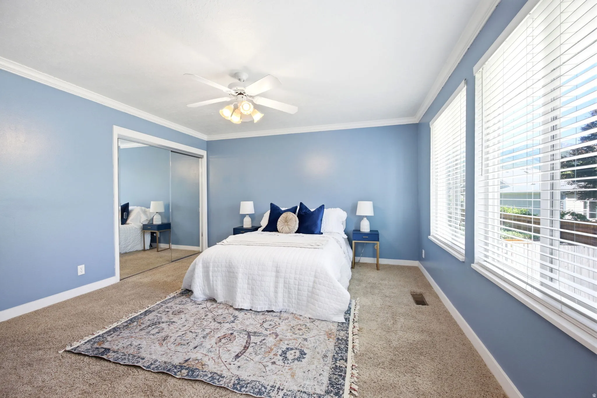 Carpeted interior space featuring light blue walls and white crown molding