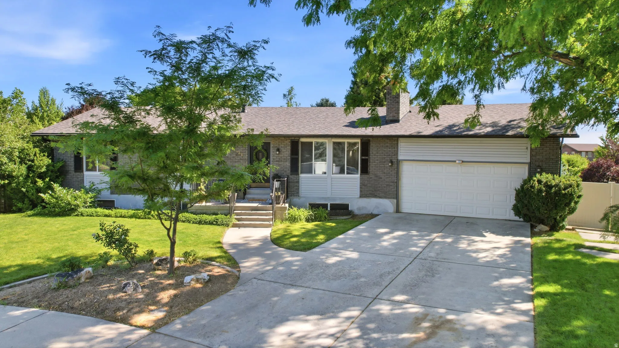 Ranch-style exterior with a gray brick facade and white siding accents