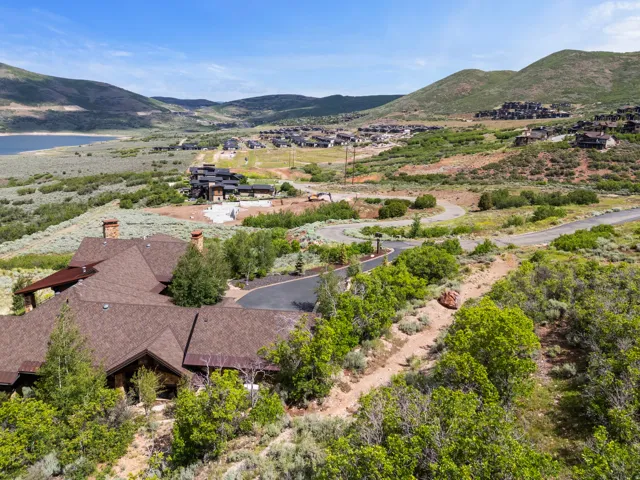Expansive property featuring a multi-gabled roofline, multiple stone chimneys, and a paved driveway