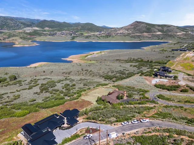 Expansive lakeside property featuring a large body of water, distant mountain range, and varied terrain with natural vegetation
