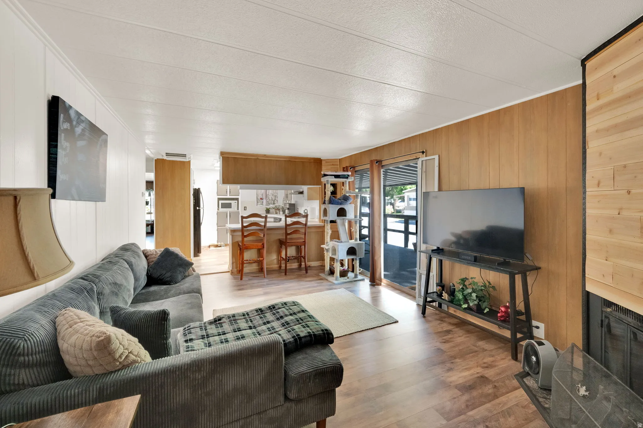 Open-concept living area featuring wood-finish flooring and a mix of vertical paneling
