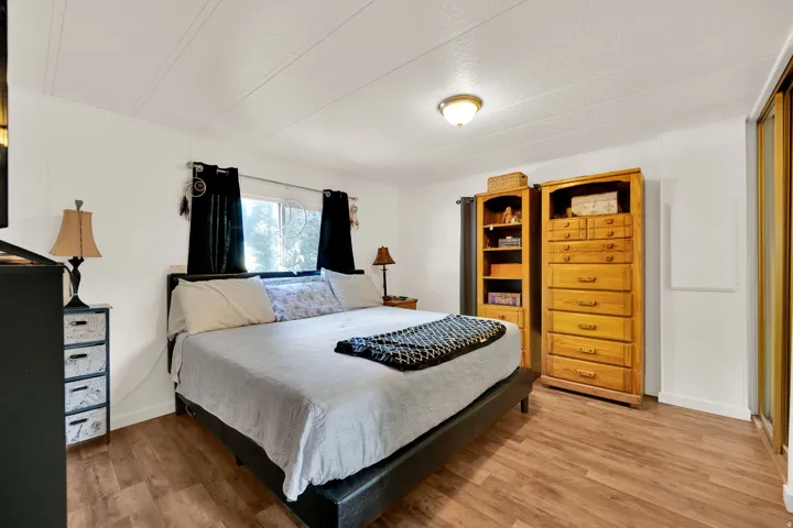 Spacious Master bedroom featuring wood-finish flooring, white walls, and a recessed ceiling light