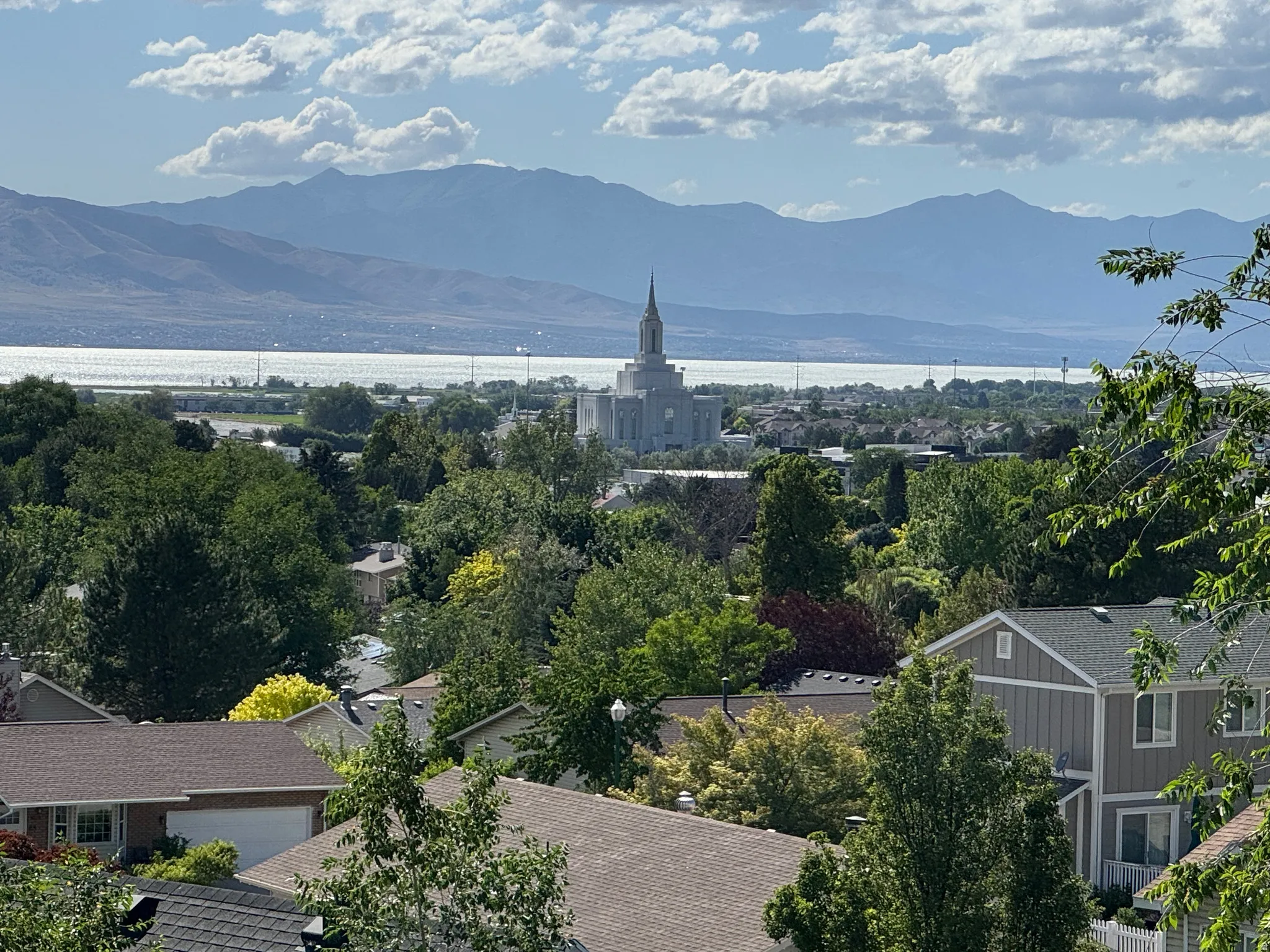 Expansive mountain and lake scenery with a distant architectural landmark