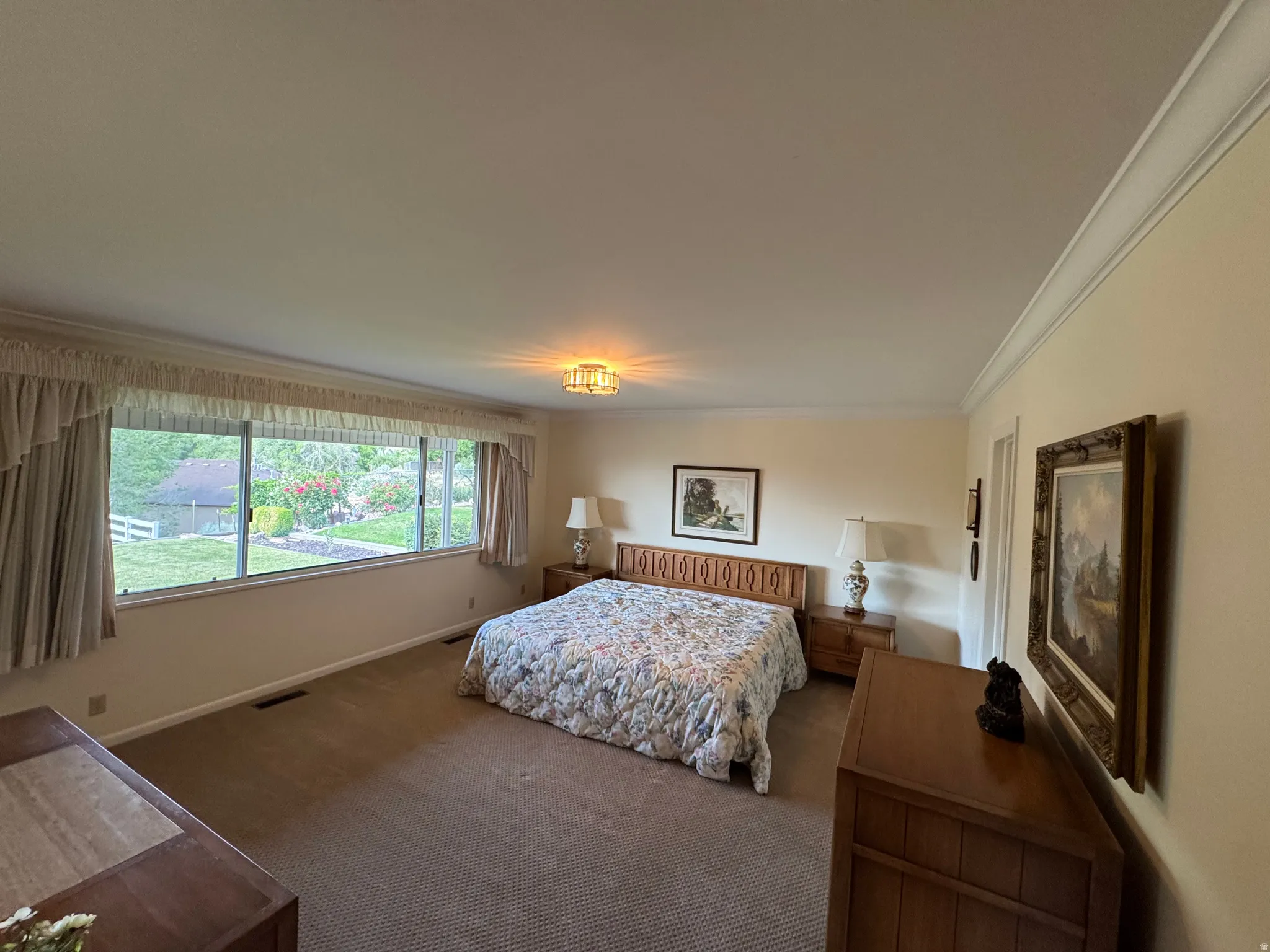 Expansive bedroom featuring wall-to-wall carpeting and a wide window offering exterior views