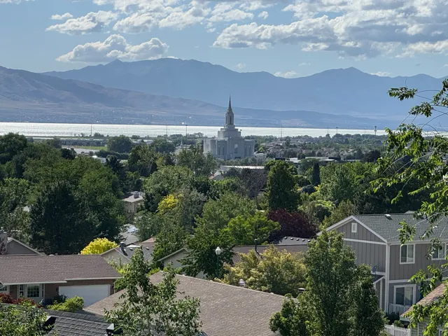 Expansive mountain and lake scenery with a distant architectural landmark