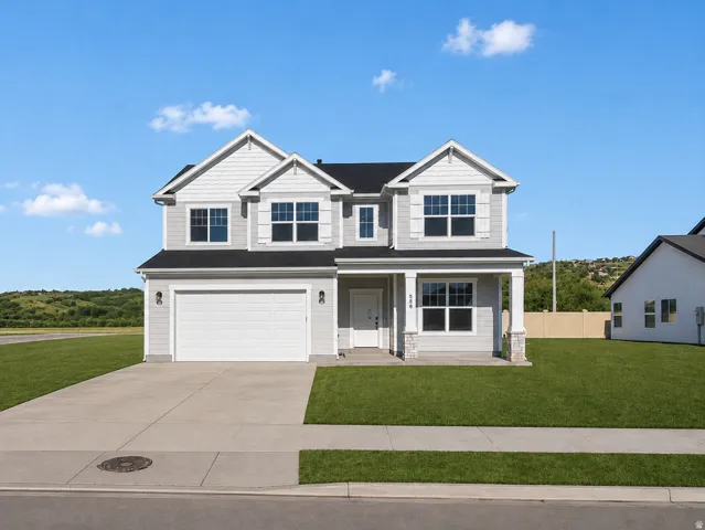 Contemporary two-story residence featuring light gray siding, white trim, a covered porch with stone-clad columns, an attached two-car garage, and a manicured front lawn