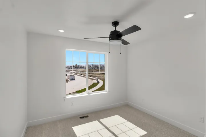 Bright room featuring a large window, recessed lighting, and a ceiling fan