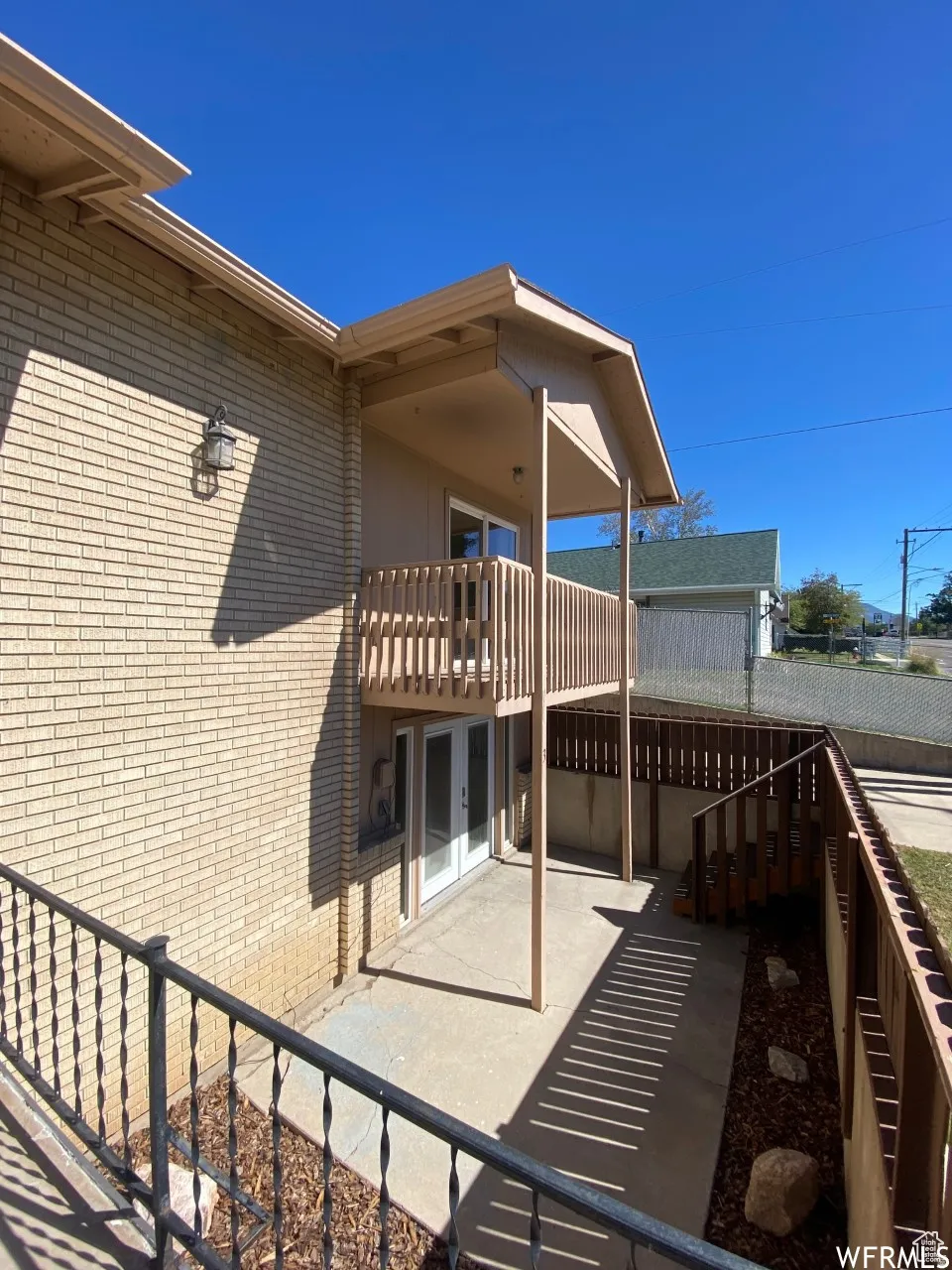 Brick exterior with a second-story balcony featuring wood railings