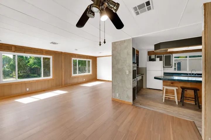 Spacious interior featuring wood-finish flooring, wood-paneled walls, and multiple large windows
