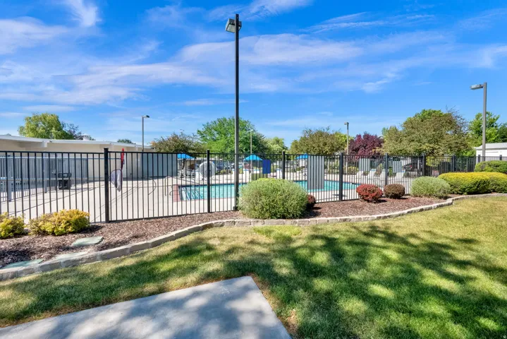 Community pool area featuring a metal fence surround and paved decking