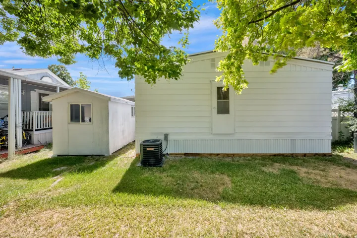 White siding exterior with a pitched roofline, featuring a side entry door