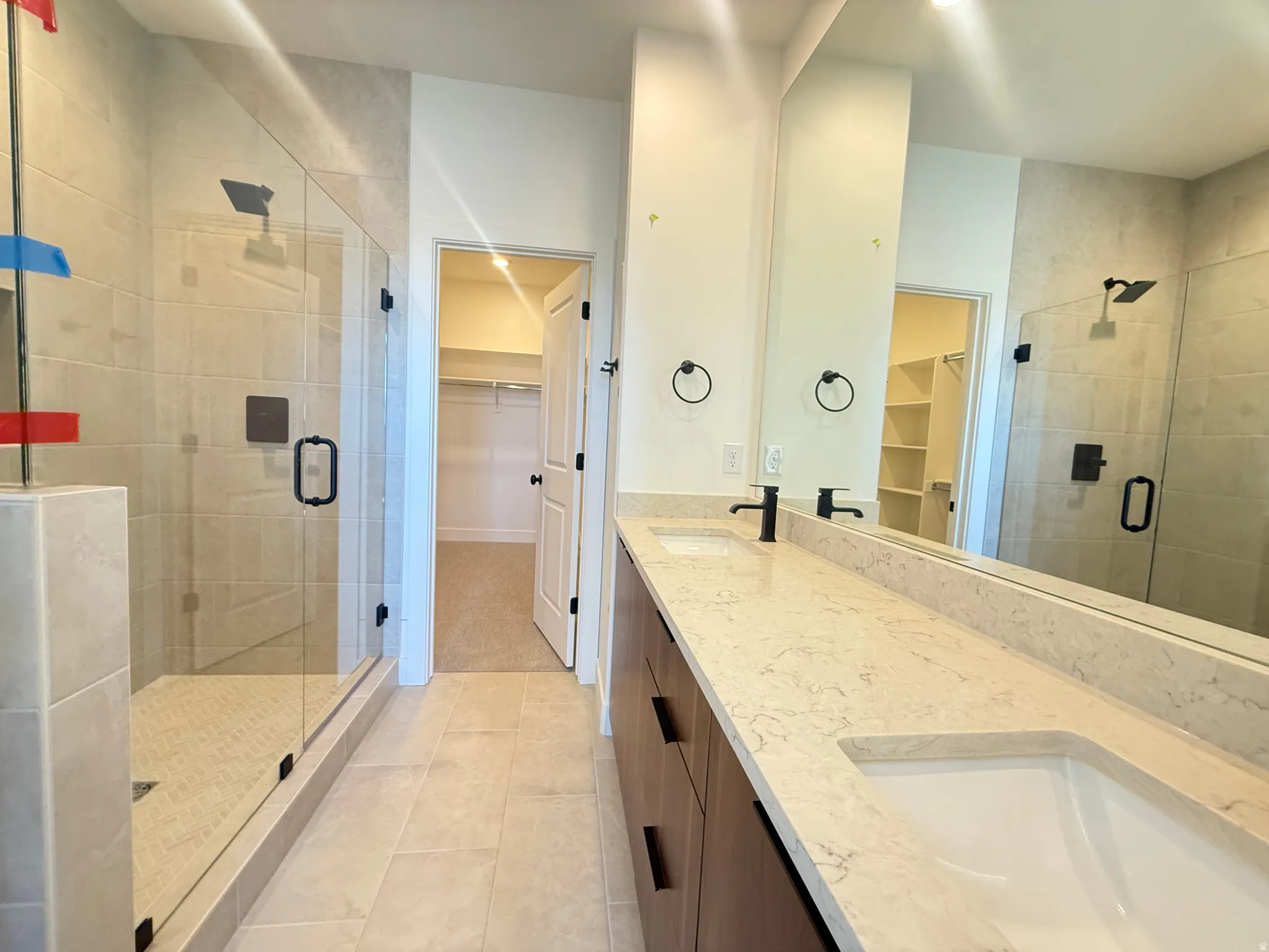 Owners suite, featuring doube vanity, tiled shower to the ceiling, Full Euro shower, and an expansive walk-in closet.