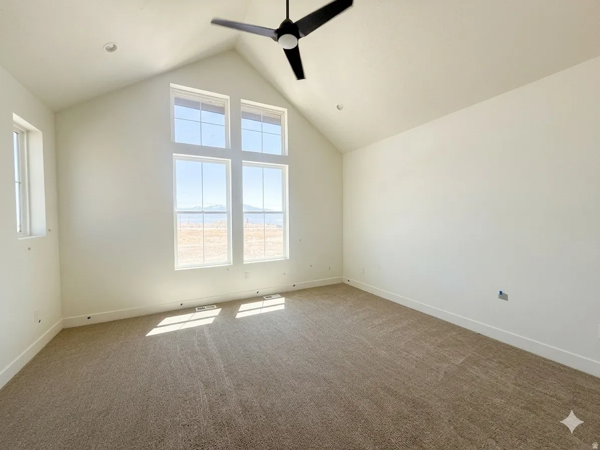 Vaulted ceiling room featuring multiple windows, recessed lighting, a ceiling fan, and carpeted flooring