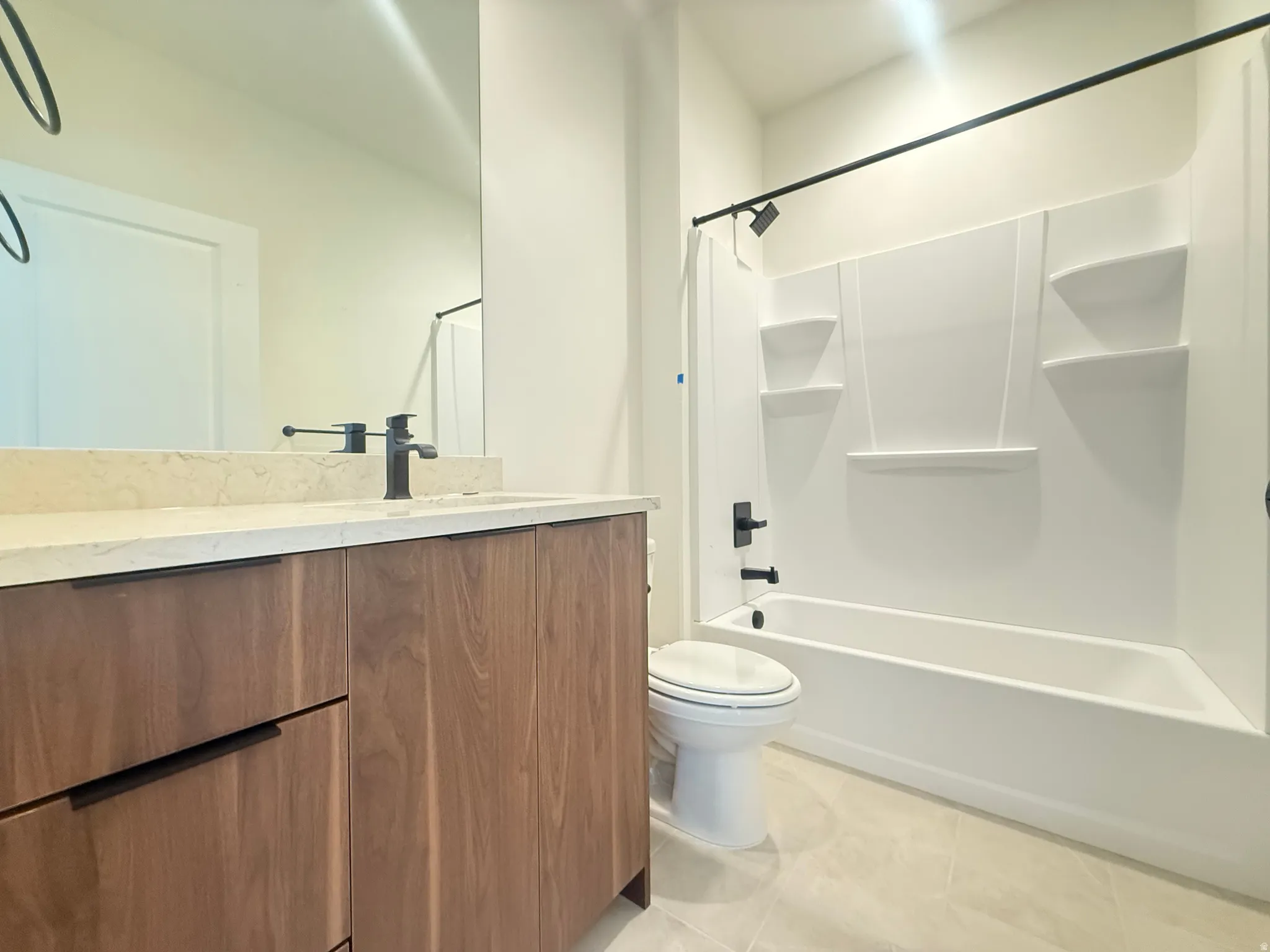 Bathroom featuring a wood-finish vanity with a light-toned countertop and integrated sink
