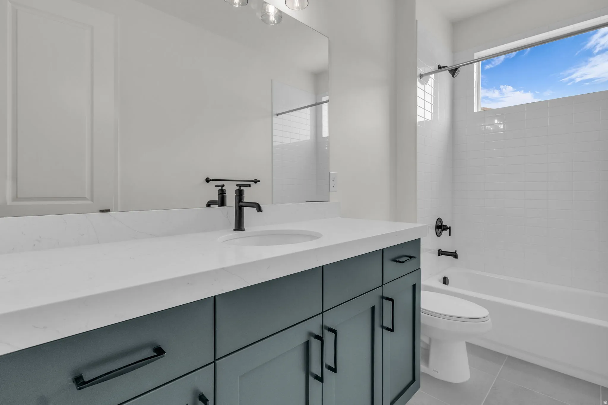 Secondary bath with painted wood cabinets and quartz slab countertops.