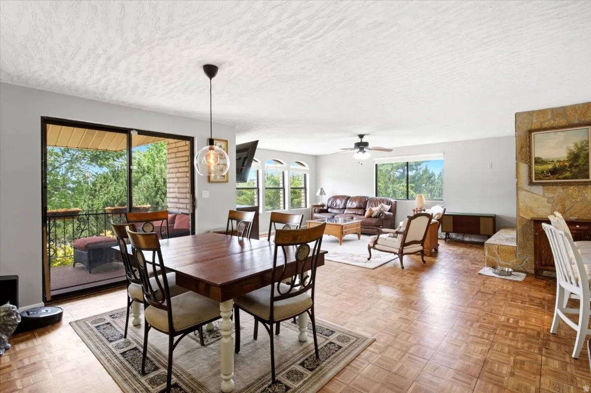 Dining area featuring wood-finish flooring, a contemporary pendant light fixture, and direct access to an outdoor balcony