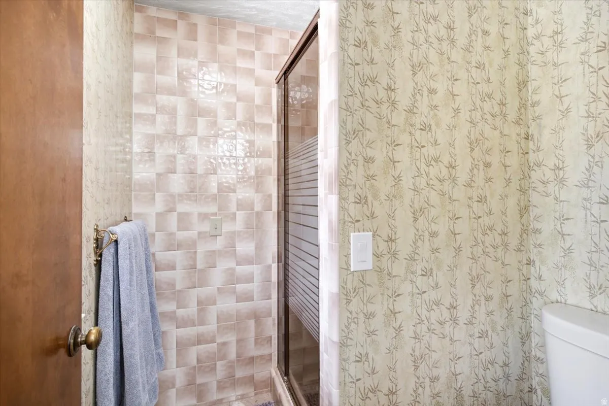 Tiled shower enclosure with a clear glass door and frosted privacy panel