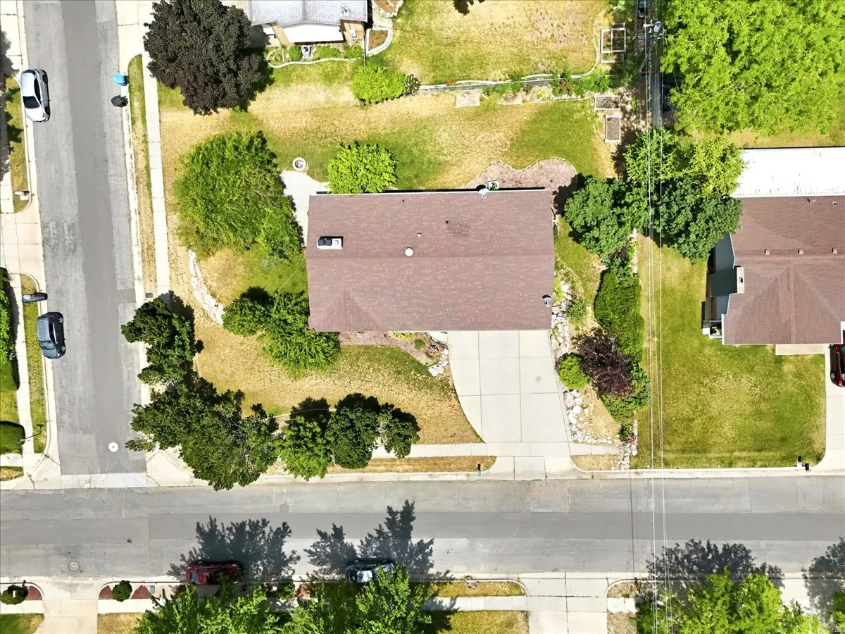 Aerial view showcasing a residential property with a brown-shingled roof