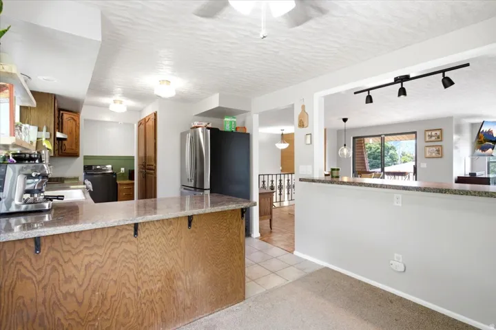 Open kitchen with wood-finish cabinetry and granite countertops
