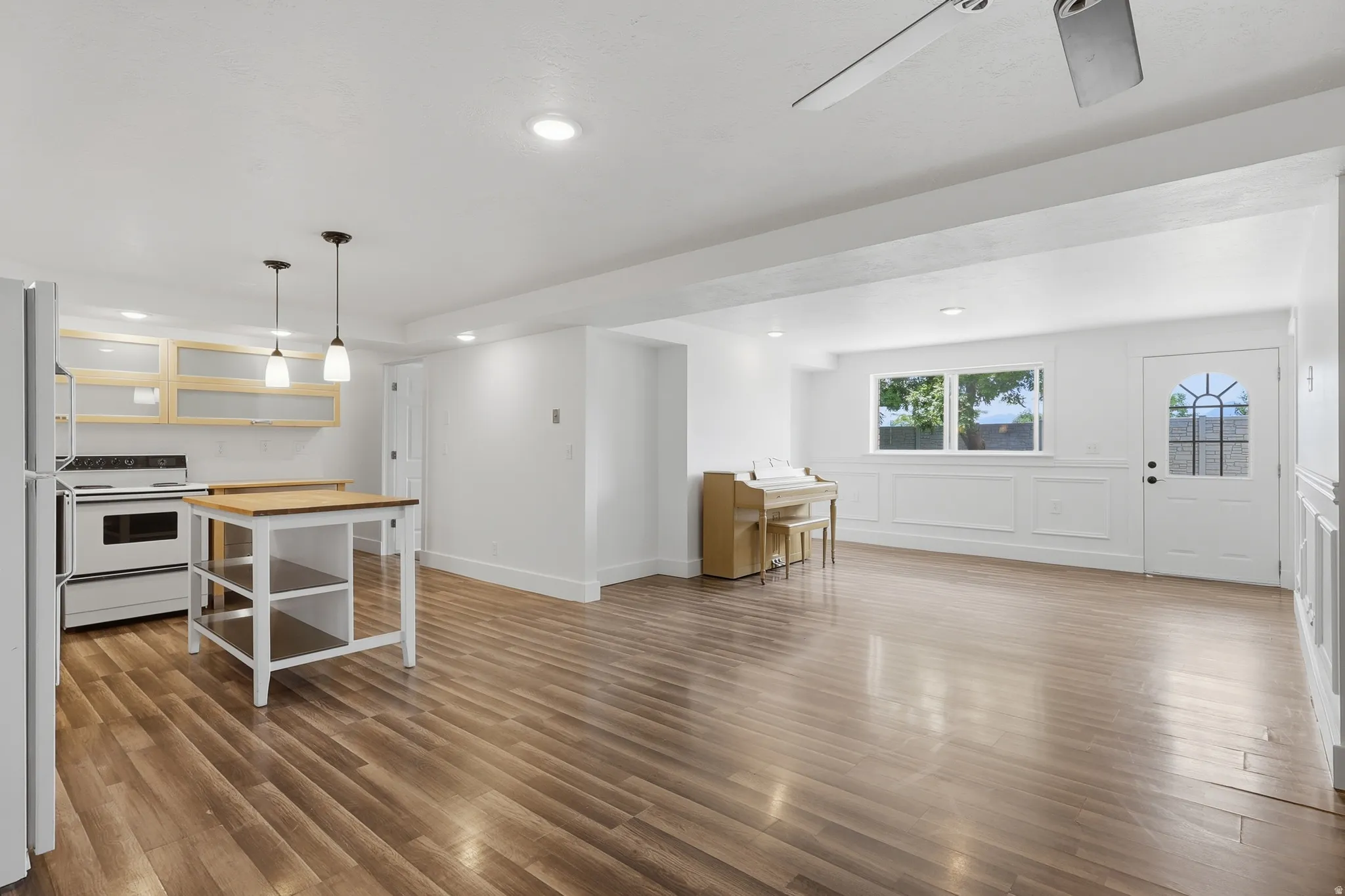 Open-concept space featuring wood-finish flooring, recessed lighting, and a ceiling fan