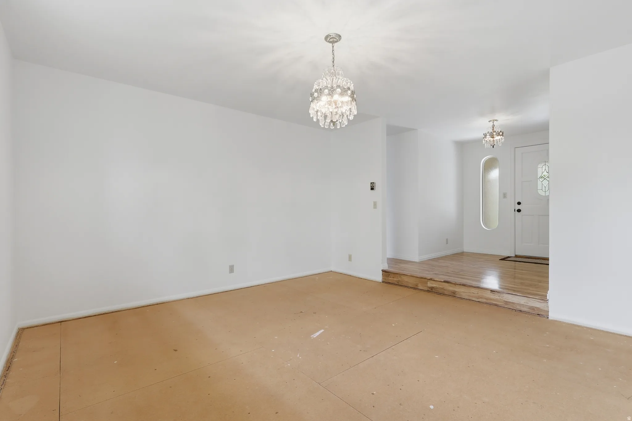 Spacious interior with neutral white walls and two crystal chandeliers