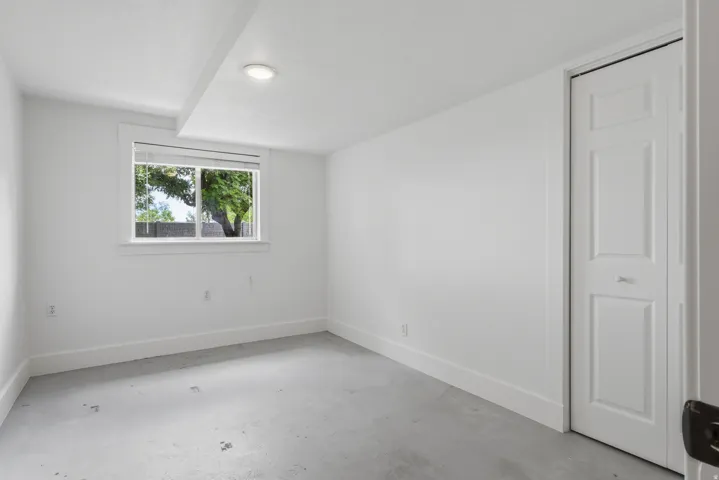 Room featuring a window with natural light, a recessed ceiling light, and a white bi-fold closet door