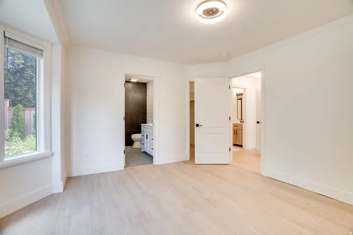 Bright interior space featuring light wood-finish flooring and crisp white walls