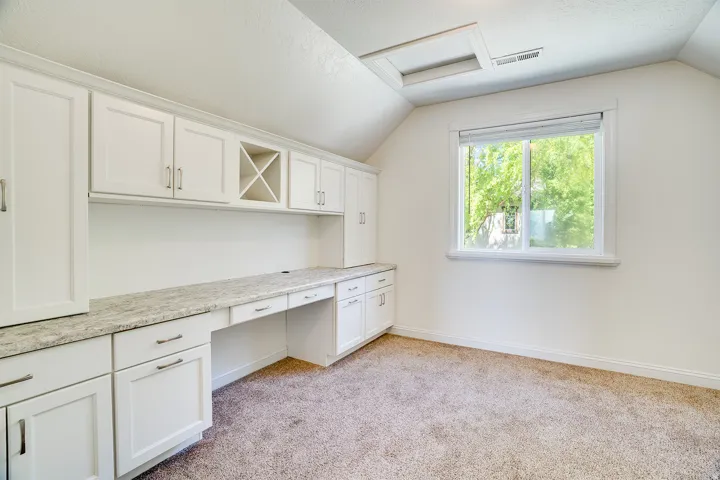 Built-in white cabinetry with a light-toned countertop and integrated desk space