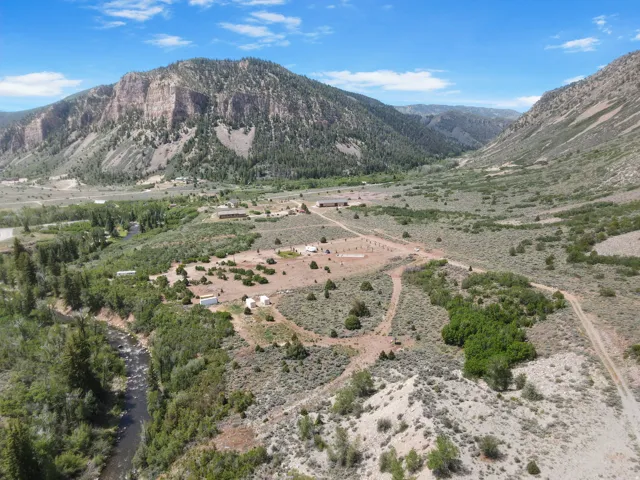 Expansive property featuring a winding river, mature tree coverage, and distant mountain ranges