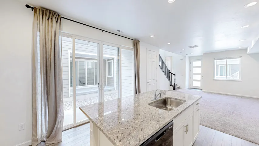 Kitchen island featuring a stainless steel sink and granite countertop