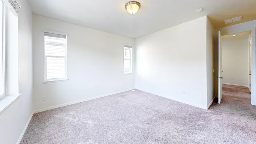 Spacious room featuring neutral carpeting and white walls