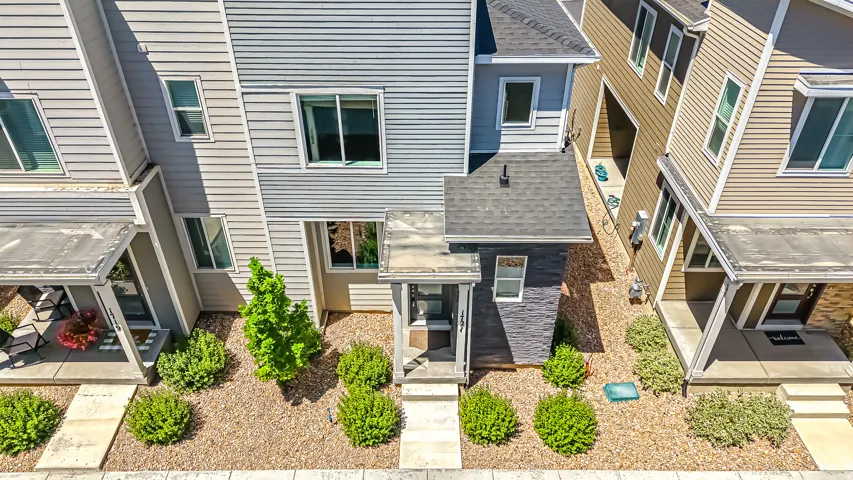Contemporary townhome exterior featuring light gray horizontal siding and a dark gray entry portico