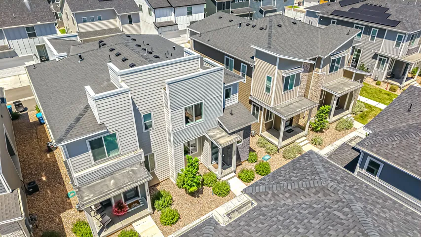 Contemporary multi-story residence featuring light gray siding and dark gray shingle roofing