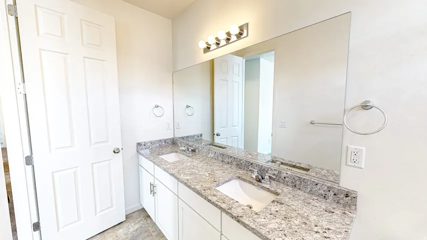 Double vanity with undermount sinks, granite countertop, and brushed nickel fixtures