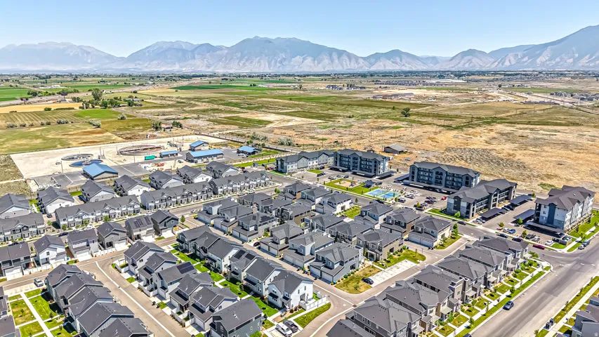 Expansive aerial view showcasing a developing residential area with modern homes and multi-story apartment buildings