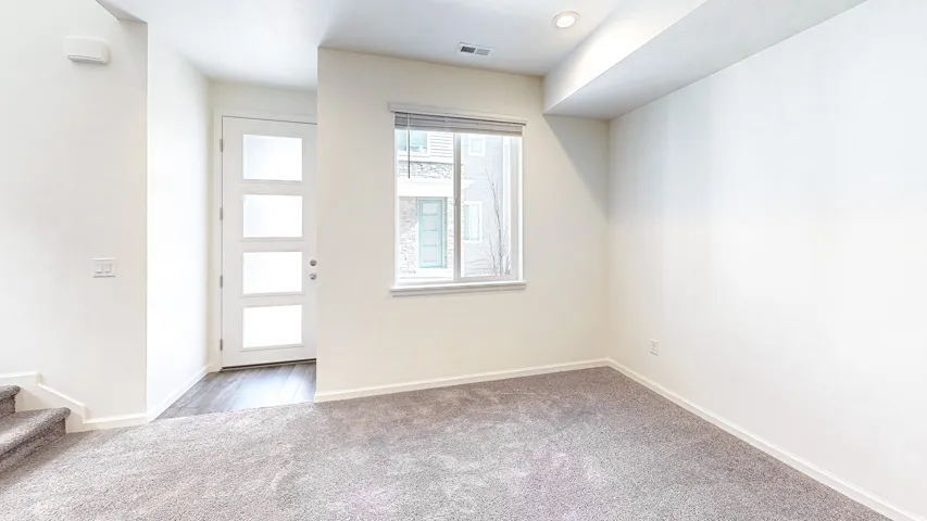 Entry area featuring a modern front door with frosted glass panels, wood-finish flooring, and recessed lighting