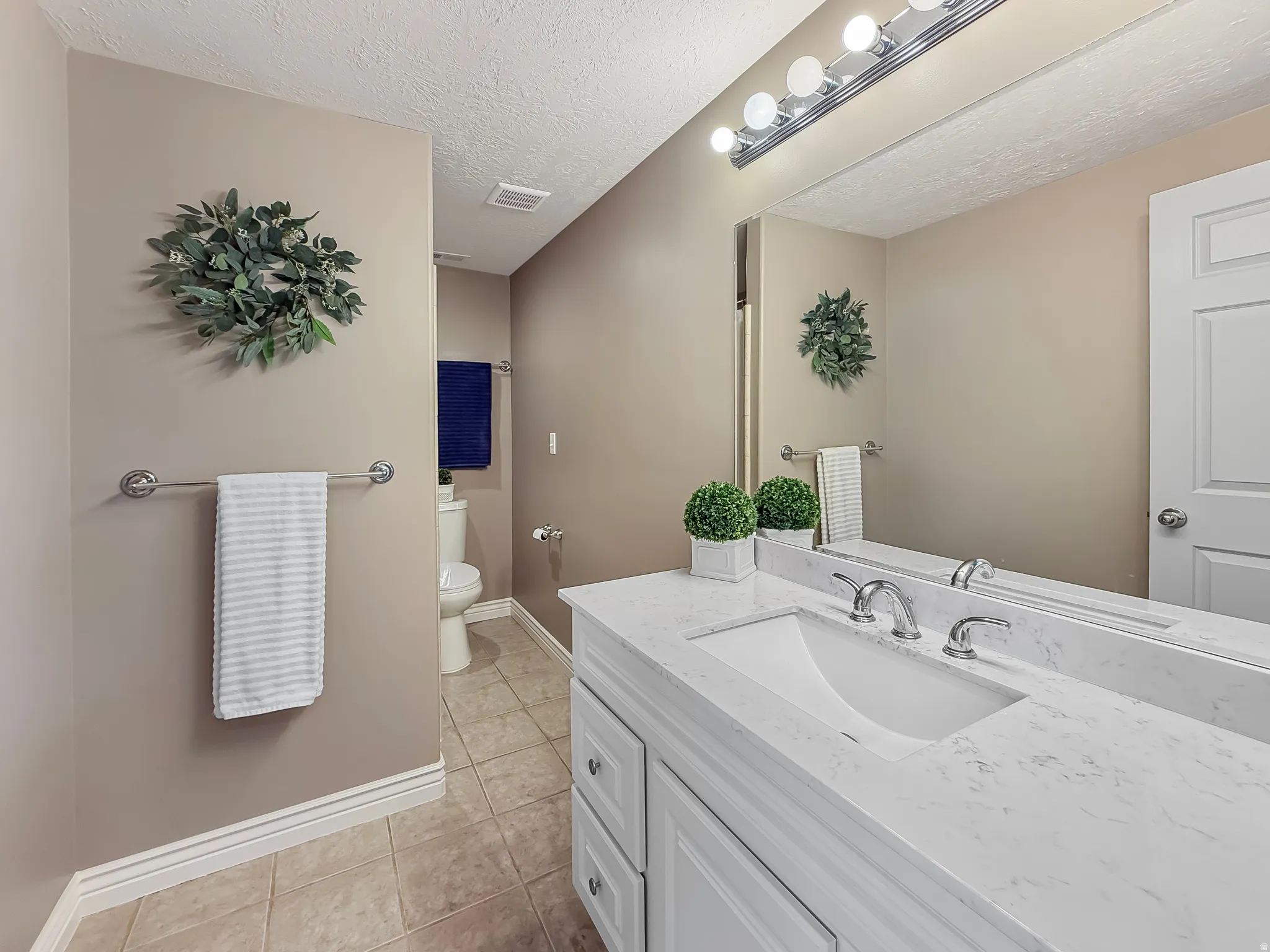 Vanity with integrated rectangular sink and polished chrome faucet, set against a large wall-mounted mirror