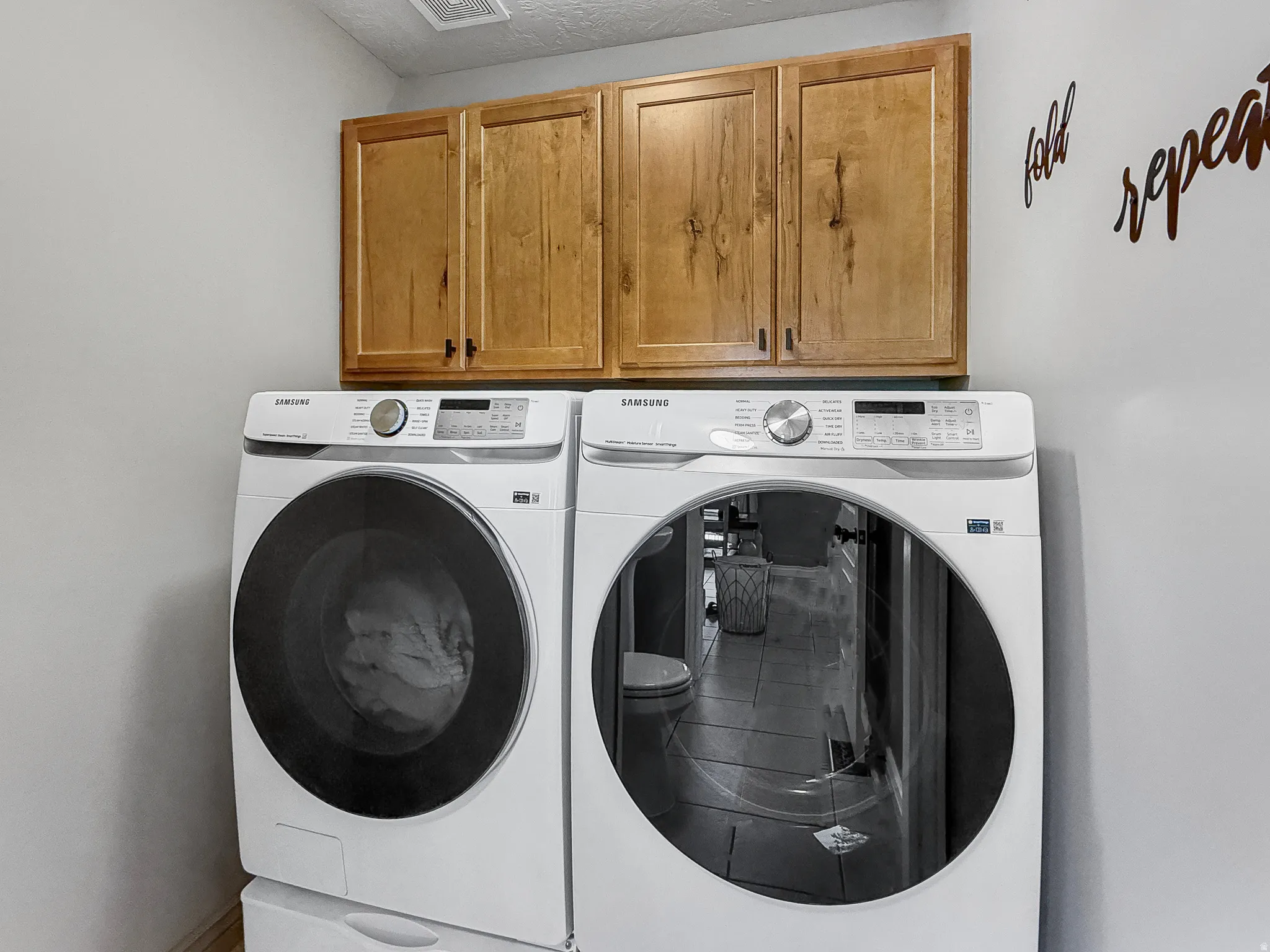 Overhead wood cabinetry with dark hardware