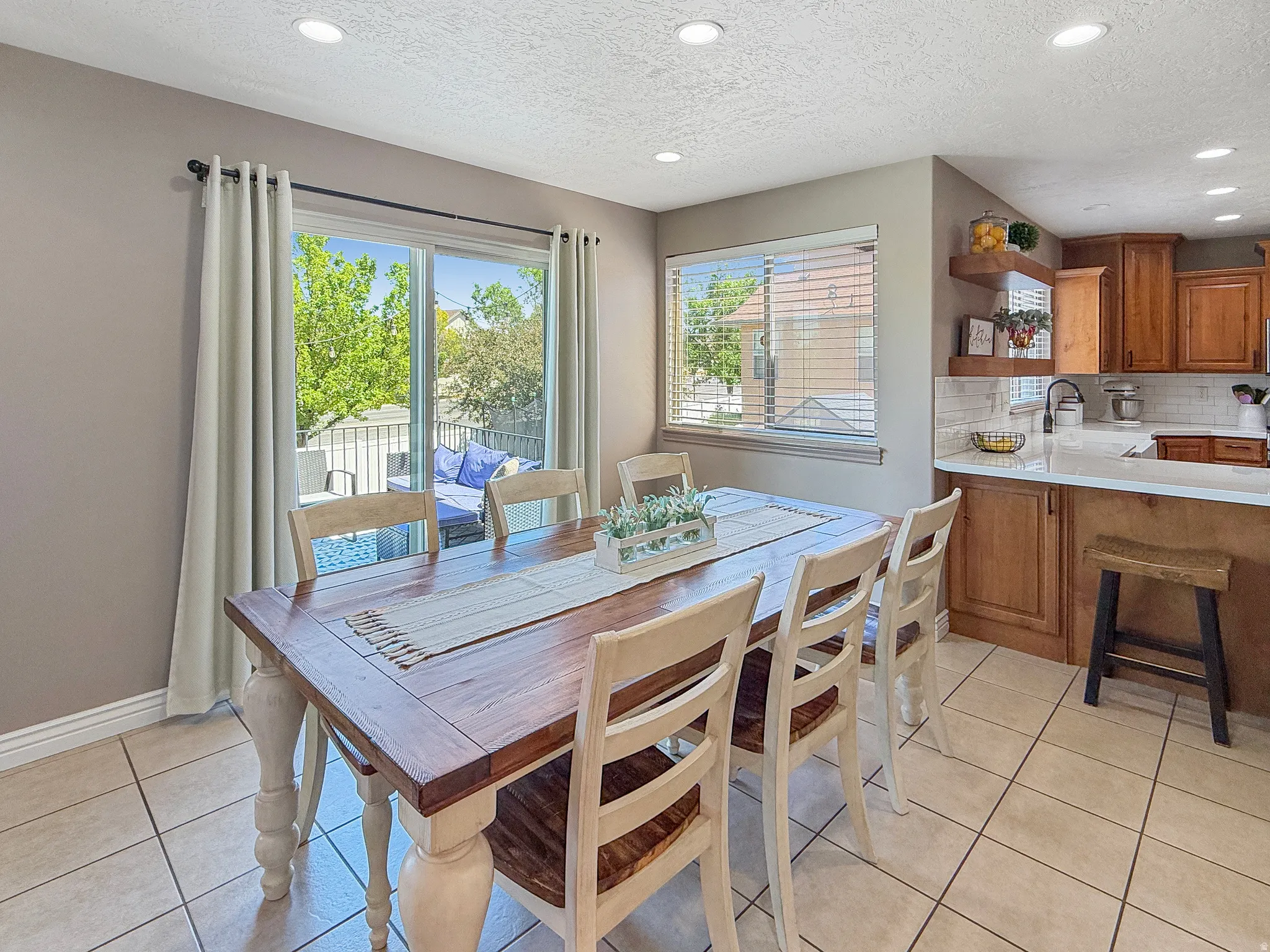Dining area featuring tile flooring, recessed lighting, and a sliding glass door providing access to an outdoor deck