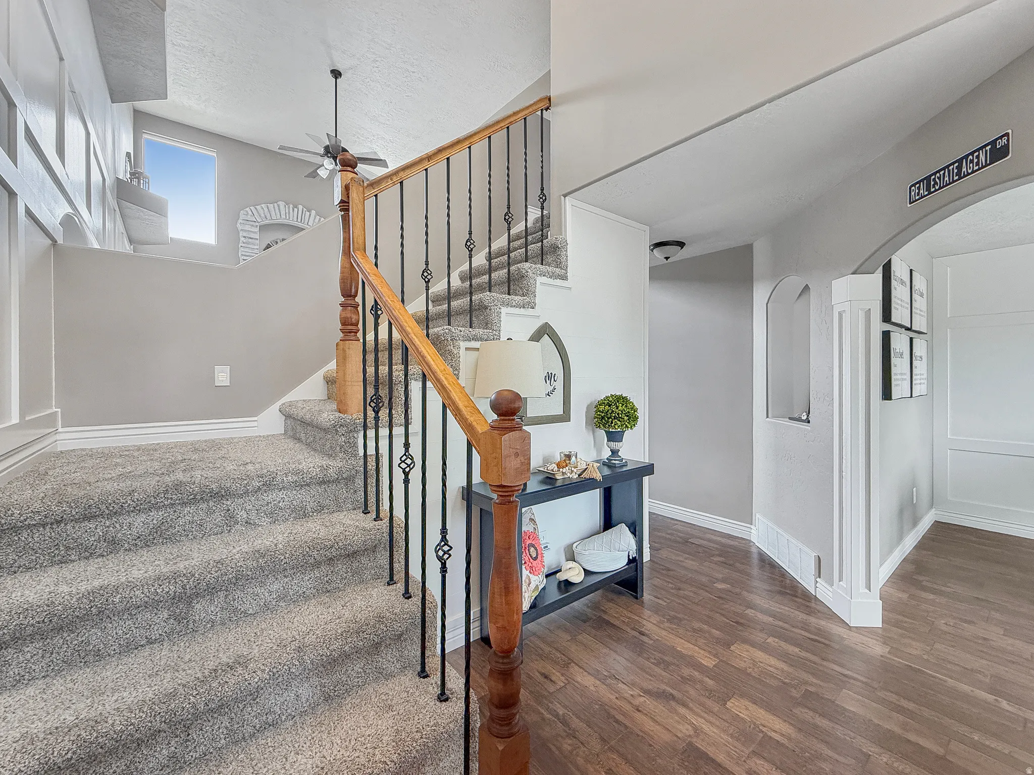 Carpeted staircase with an ornamental wrought iron and wood balustrade