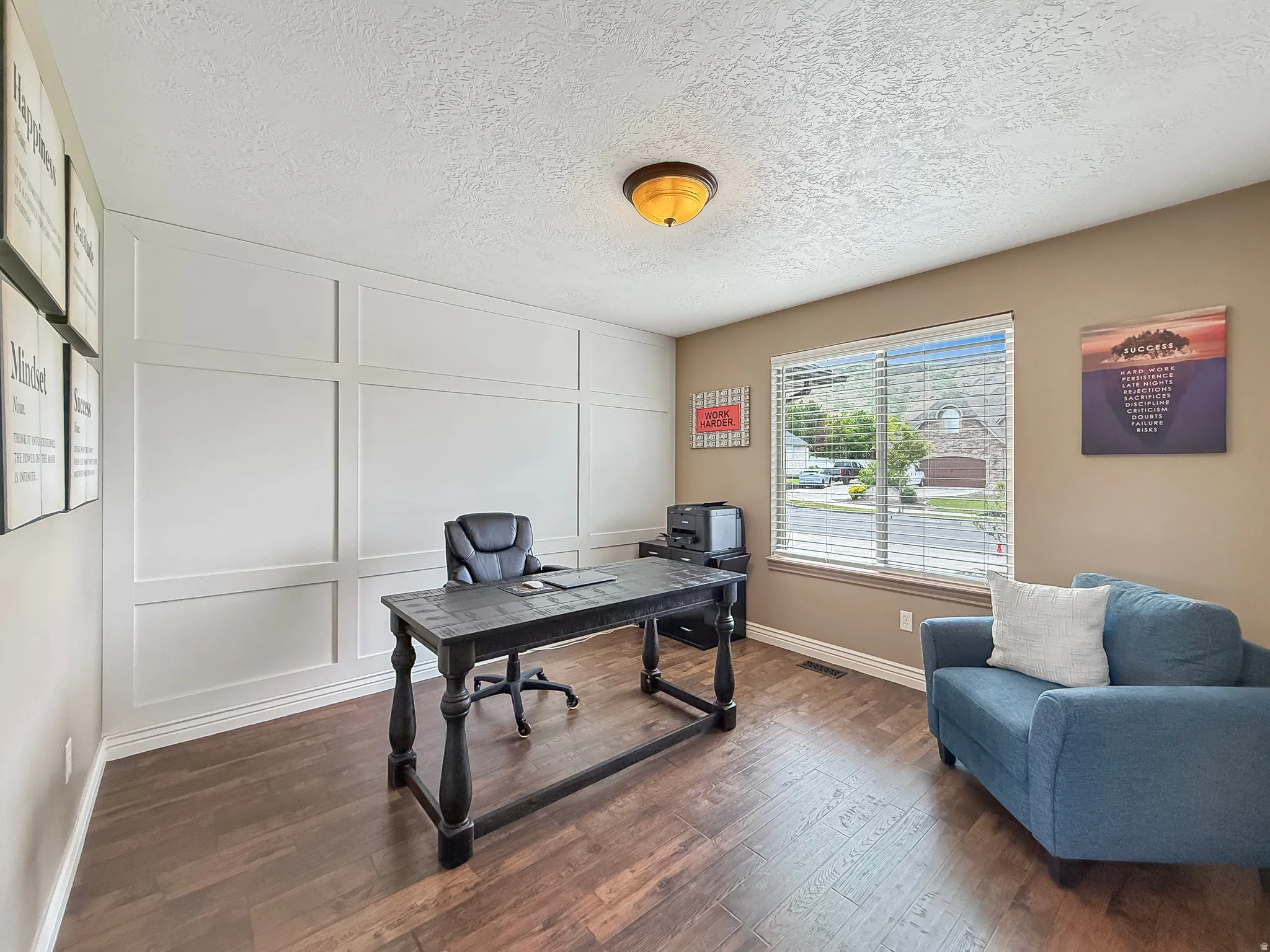 Interior room featuring wood-finish flooring, a window with blinds, and white wainscoting on one wall
