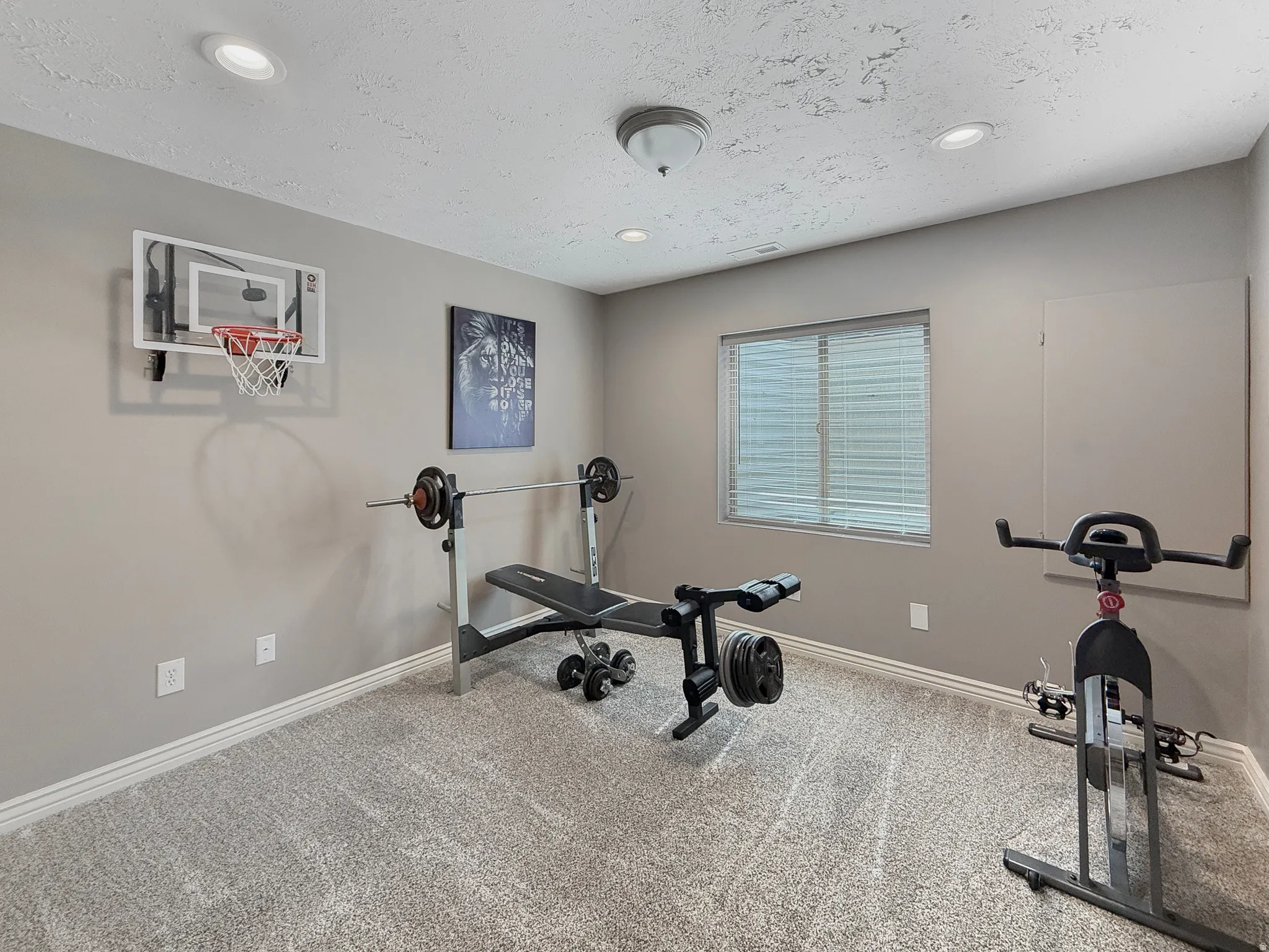 Carpeted room featuring a window with blinds, recessed lighting, and a flush mount ceiling fixture