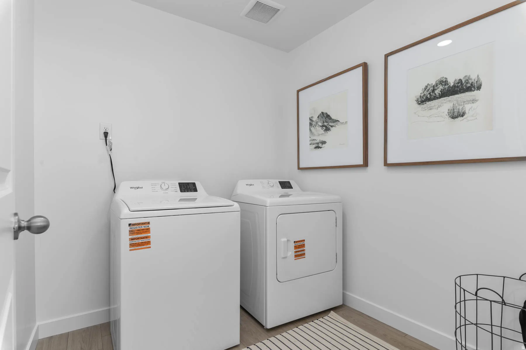 Dedicated laundry area with light wood-finish flooring